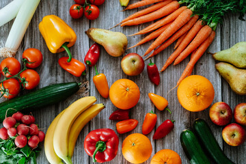 Fresh, healthy, colorful composition from various raw, seasonal fruits and vegetables, food still life on a wooden background