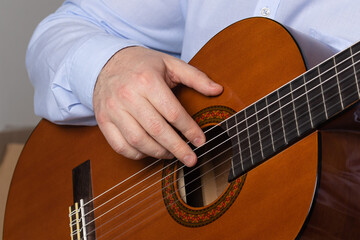 man shows guitar chords. Playing guitar close up