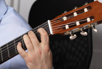 man shows guitar chords. Playing guitar close up