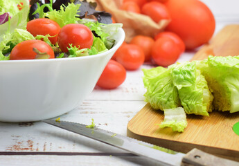 Mixed salad, accompanied by small tomatoes. Healthy contour.