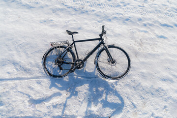 Naklejka na ściany i meble Black bicycle on snow background at winter season
