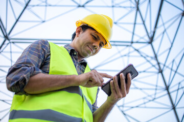 Electrical engineers using smartphone in high voltage pole