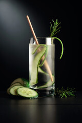 Cold refreshing drink with ice, cucumber, and rosemary.