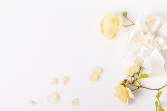 Flowers composition. Frame made of romantic yellow rose flowers and petals on white background