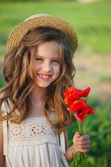 cute little girl in meadow with red poppies