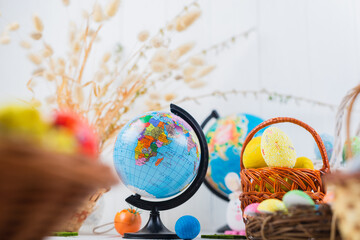 Multi-colored Easter eggs in a basket on a white wooden background