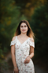 Blonde girl in summer light dress in summer outdoors