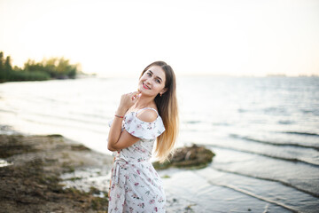 Blonde girl in summer light dress in summer outdoors