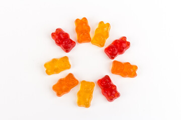 Children's vitamins in the form of bears are arranged in rows. A lot of multi-colored jelly sweets...