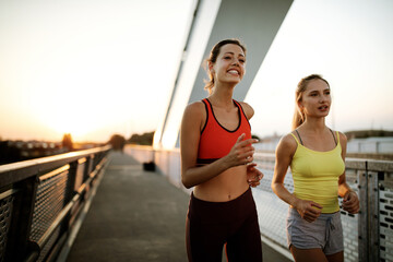 Early morning workout. Happy people running across the bridge. Living healthy lifestyle.