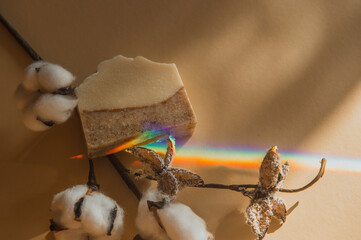 Handmade soap, cotton branch and rainbow on beige background. Zero waste, eco friendly cosmetics concept Minimalism flat lay composition for bloggers, artists, social media, magazines