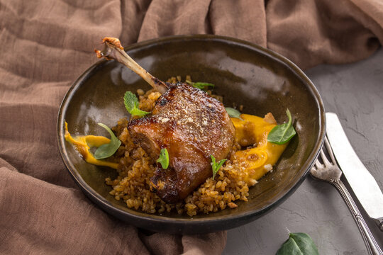 Duck confit Roasted duck leg with puree on brown plate on the table