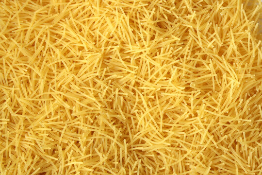 Dry uncooked vermicelli pasta as a background.