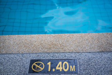 close up image of signs of depth in meters in swimming pool, deep pool with blue water, no people...