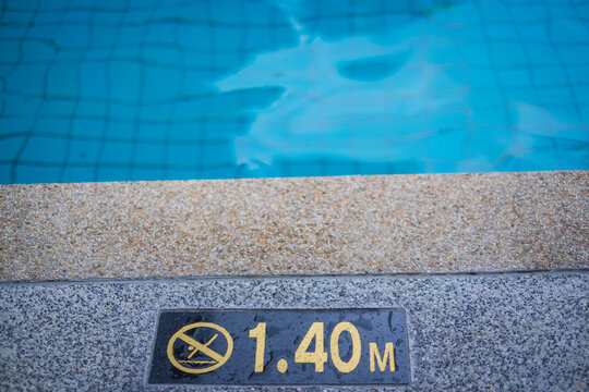 close up image of signs of depth in meters in swimming pool, deep pool with blue water, no people around, safety on water. Swimming pool sign.