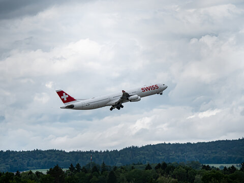 Swiss a340 takin off at ZRH from behind a patch of forest