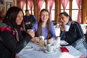 Three women hikers having a coffee break in a restaurant