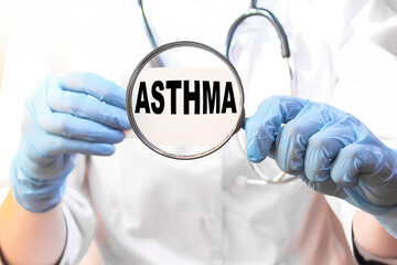 The doctor's blue - gloved hands show the word ASTHMA - . a gloved hand on a white background. Medical concept. the medicine