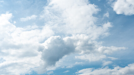 Beautiful fluffy clouds in the evening sky. The sunlight gives a side light on the clouds. Clouds before rain.
