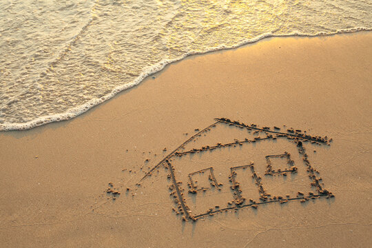 Soft surf and house painted on sea beach sand.
