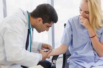 male doctor is using a syringe to inject a female patient