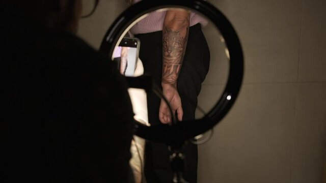 Tattooist taking photo of tattoo on arm of client