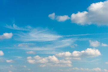Beautiful fluffy clouds in the evening sky. The sunlight gives a side light on the clouds. Clouds before rain.