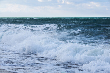 Naklejka na ściany i meble waves run onto the beach on the shore of the winter sea