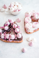 Cake in the shape of a heart from Traditional French dessert eclair and Pavlov cookies on a white background. .Valentine's day concept