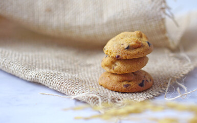3 pieces of cookies arranged in stack on sackcloth and white table, minimal style
