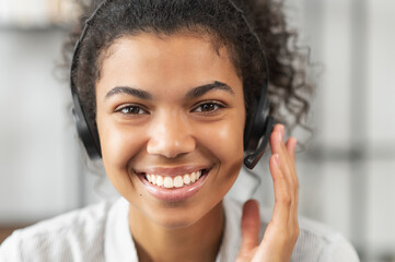 Headshot portrait close-up smiling African American woman support service operator in headset...