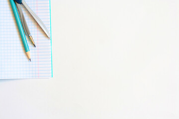 Notebook, compass and pencil on a white background, copy space