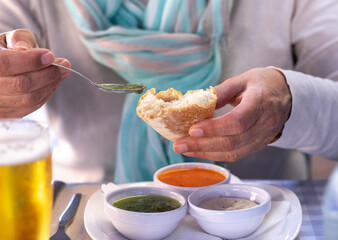 At the restaurant table a woman tastes one of the.typical sauces of the Canary Islands, called 