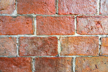 Red brick wall or clay stone wall with glaze coating surface during natural lighting reflect on it. Background and Texture of building photo.