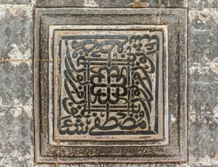 Vijayapura, Karnataka, India - November 8, 2013: Ibrahim Rauza Mausoleum. Closeup of gray stone square non-figurative sculpture on wall.