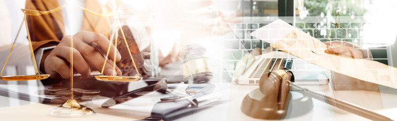 Justice and law concept.Male judge in a courtroom with the gavel, working with, computer and docking keyboard, eyeglasses, on table in morning light