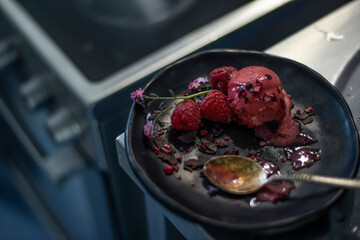 raspberry homemade ice cream on plate in the kitchen low light selective focus
