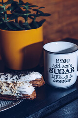 Close-up shot of a traditional French dessert eclair with white chocolate and a cup with the...