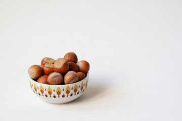 Hazelnuts in a bowl on a white background