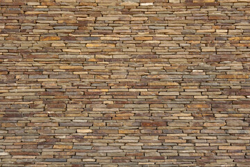A wall of natural flat stones laid out horizontally. Texture for background.