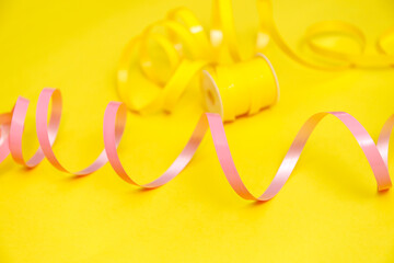 Colorful balloons and confetti on yellow table top view. Festive or party background. Flat lay style. Birthday greeting card. Carnival.