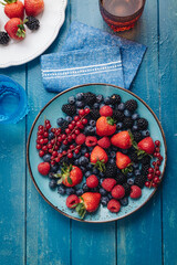 Healthy breakfast eating a mix of fresh berries fruits