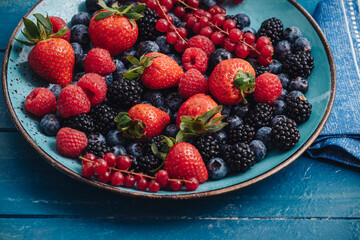 Healthy breakfast eating a mix of fresh berries fruits