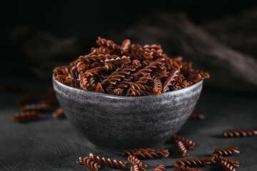 Organic uncooked Buckwheat Fusilli pasta on a dark background