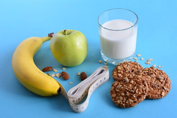 healthy food and centimeter tape on the blue background