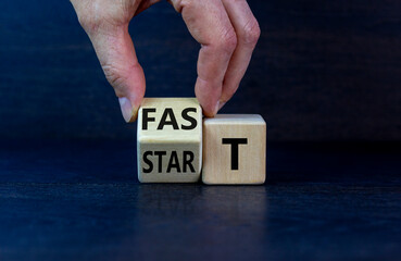 Time to fast start symbol. Businessman turns a wooden cube with words 'fast start'. Beautiful grey...