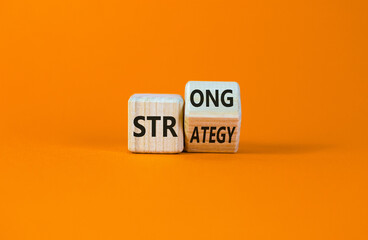 Strong strategy symbol. Turned a wooden cube with words 'strong strategy'. Beautiful orange...
