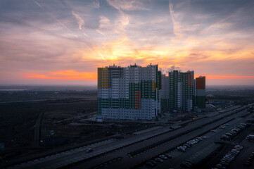 Naklejka na ściany i meble evening cityscape with a beautiful sunset sky and a multi-storey residential building with a road, Rostov-on-Don