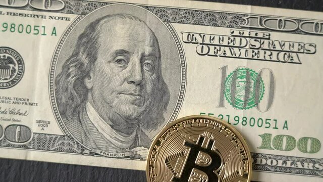 Bitcoin cryptocurrency equivalent to dollar, a banknote of one hundred units. Future virtual currency concept. On a background of marble, close-up.