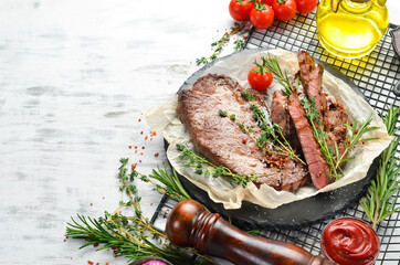 Beef steak. Veal, meat with spices and vegetables on a white wooden background. Flat lay. Top view.